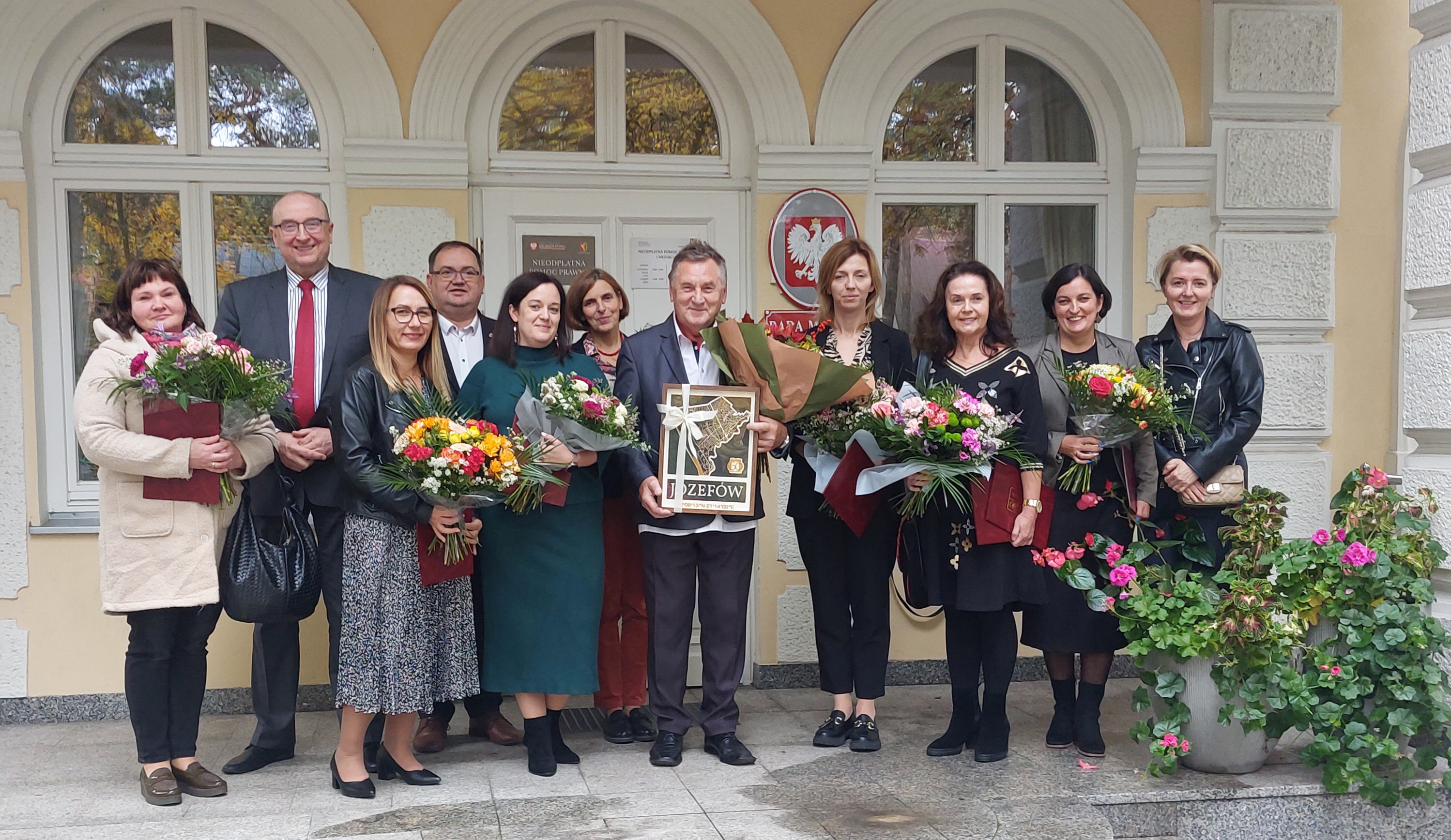 Grupa osób stoi na schodach przed wejściem do Rady Miasta
