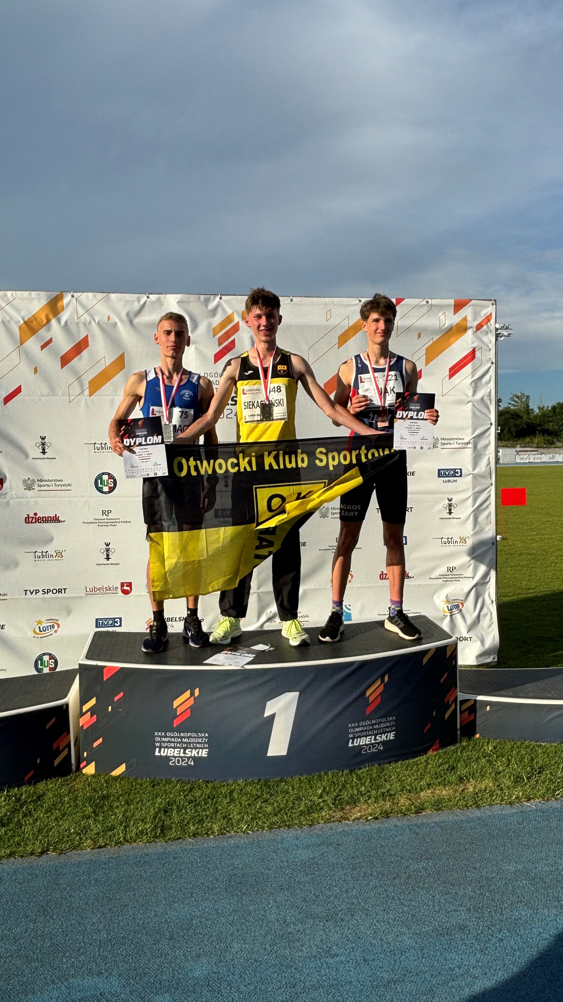 Trzech sportowców na podium.