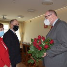 Burmistrz Marek Banaszek i kierownik USC Marzena Szczęśniak wręczają medal, kwiaty i dyplom parze małżeńskiej