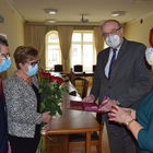 Burmistrz Marek Banaszek i kierownik USC Marzena Szczęśniak wręczają medal, kwiaty i dyplom parze małżeńskiej