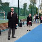 Burmistrz Marek Banaszek przemawia do mikrofonu. Na drugim planie dyrektor Jolanta Czarnecka. W tle uczniowie.