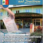 Ręka wrzuca ankietę do urny do głosowania. W tle budynek Urzędu Miasta.