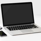 Laptop. Po prawej stronie jabłko, po lewej telefon.