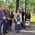 Na zdjęciu Burmistrz Marek Banaszek wita gości. Grupa osób stoi w półokręgu