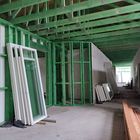 Budowa Miejskiego Przedszkola nr 1 - na fotografii widoczne wnętrze budynku, ściany szkieletowe, belki stropowe zielone, pod ścianą zmagazynowano okna czekające na montaż