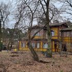 Budynek drewniany w stylu świdermajer w kolorze beżowym